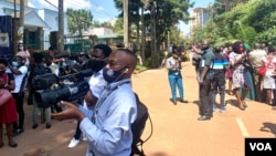 Journalists in Kampala stand in the middle of the road as they cover their protest against Security brutality. (Halima Athumani/VOA)jpg (3.2 MB)