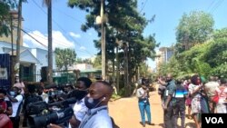 Journalists in Kampala stand in the middle of the road as they cover their protest against Security brutality. (Halima Athumani/VOA)