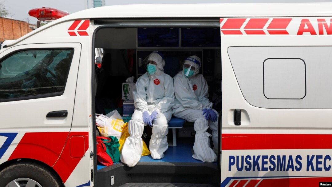 Petugas medis mengenakan pakaian pelindung di dalam ambulans setelah mengumpulkan sampel usap untuk pengetesan virus corona (Covid-19) di pasar tradisional di Jakarta, 2 Juli 2020. (Foto: Reuters)