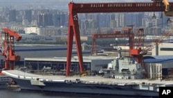 In this photo taken on Aug. 6, 2011, a Chinese aircraft carrier, which had been under refurbishment, is docked at Dalian port in in northeastern Liaoning province.