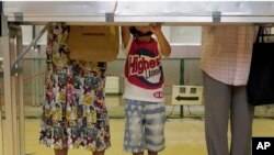 Voters pick candidates and party before casting ballots in Japan's upper house parliamentary elections, Tokyo, July 21, 2013.