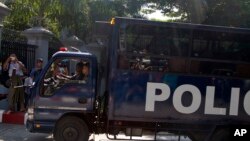 Police vehicle carrying defendants arrives at a district court in Yangon, Myanmar, Dec. 15, 2017. 