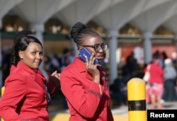 A Kenya Airways flight attendant uses her cell phone as they gather at the Jomo Kenyatta International Airport near Nairobi, Kenya, March 6, 2019.