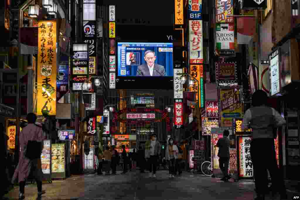 스가 요시히데 일본 총리가 신종 코로나바이러스 비상사태의 연장을 발표하는 뉴스가 도쿄 거리의 대형 스크린 나오고 있다.