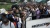 People queue to try to cross into Venezuela from Colombia through the Simon Bolivar international bridge in Cucuta, Colombia, Feb. 13, 2018.