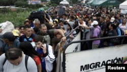 People queue to try to cross into Venezuela from Colombia through the Simon Bolivar international bridge in Cucuta, Colombia, Feb. 13, 2018.