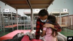 Ana María Moreno Portillo, de Guatemala, abraza a su hija tras ser deportadas de Estados Unidos, en el Complejo Deportivo Kiki Romero en Ciudad Juárez, México, el lunes 5 de abril de 2021.