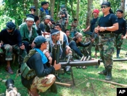 Juru bicara Abu Sayyaf Abu Sabaya, di latar depan, terlihat bersama kelompok ekstremis bersenjata. Pasukan Filipina menangkap seorang komandan pemberontak Abu Sayyaf yang disalahkan atas penculikan uang tebusan selama bertahun-tahun dan pada hari Minggu, 21 Maret 2021. (Foto: AP)