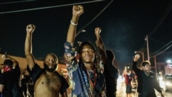 TOPSHOT - Protesters raise their fists during a demonstration against the shooting of Jacob Blake in Kenosha, Wisconsin on August 26, 2020. - Two people were shot dead and a third injured on the night of August 25 in the US city of Kenosha as anti…