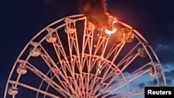 Columnas de humo salen de una noria en llamas en el Highfield Festival en Grosspoesna, Alemania, el 17 de agosto de 2024, en esta captura de pantalla obtenida de un video de las redes sociales.