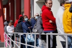 FILE - People wait in line for help with unemployment benefits in Las Vegas, Nevada, March 17, 2020.