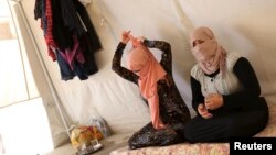 FILE - Yazidi sisters, who escaped from captivity by Islamic State (IS) militants, sit in a tent at Sharya refugee camp on the outskirts of Duhok province, Iraq, July 3, 2015. 