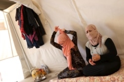 FILE - Yazidi sisters, who escaped from captivity by IS militants, sit in a tent at Sharya refugee camp on the outskirts of Duhok province, Iraq, July 3, 2015.