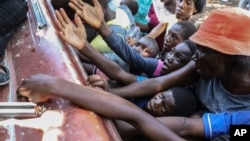 ARCHIVO: Haitianos desplazados por las pandillas reciben alimentos de una ONG en Saint-Marc, Haití, el 6 de octubre de 2024.