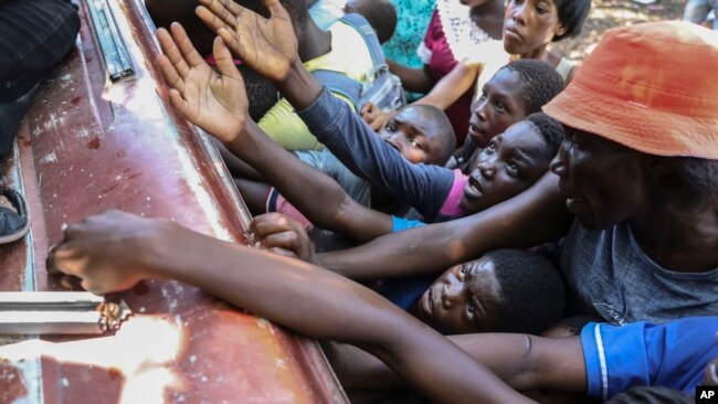 ARCHIVO: Haitianos desplazados por las pandillas reciben alimentos de una ONG en Saint-Marc, Haití, el 6 de octubre de 2024.