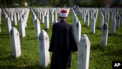 (FILE) A Bosnian Muslim effendi walks through the memorial cemetery in Bosnia.
