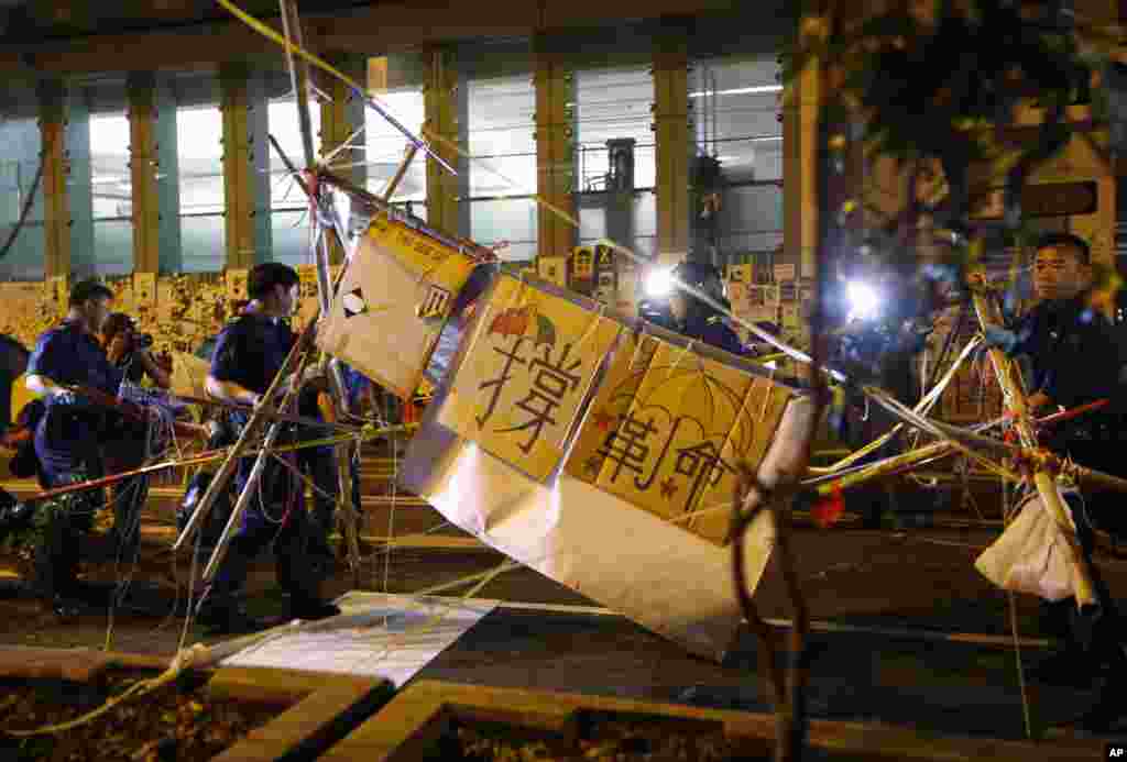 Riot police remove barricades in the Mong Kok district of Hong Kong, early Friday, Oct. 17, 2014.