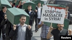 Manifestantes cargan ataúdes para exigir al gobierno que detenga las matanzas de civiles en la ciudad de Izmir.