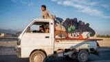 (FILES) In this photograph taken on November 12, 2023, Afghan refugees with their belongings sit atop a truck as they head from a makeshift camp near the Afghanistan-Pakistan Torkham border to Jalalabad, after their deportation from Pakistan, in the Ghani