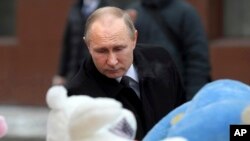 Presiden Vladimir Putin meletakkan karangan bunga pada lokasi untuk mengenang para korban kebakaran di pusat perbelanjaan kota Kemerovo, Siberia, Rusia, Selasa (27/3). 