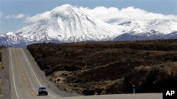 Sebuah mobil melintasi jalanan didekat gunung Tongariro yang diselimuti salju di Selandia Baru (Foto: dok). Gunung Tongariro meletus Senin petang (6/8) menyemburkan abu setinggi 6.000 meter.