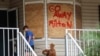 Noah Weibel and his dog Cookie climb the steps to their home as their family prepares for Hurricane Milton, in New Port Richey, Florida, Oct. 7, 2024.