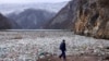 Seorang operator mesin derek berjalan melewati pinggiran sungai Drina, yang diselimuti tumpukan sampah, di dekat Visegrad, Bosnia, pada 10 Januari 2024. (Foto: AP/Armin Durgut)