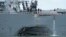 FILE - damage is visible as the guided-missile destroyer USS John S. McCain steers towards Changi naval base in Singapore following a collision with the merchant vessel Alnic MC. 