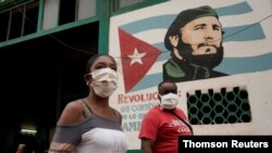 CIudadanos cubanos emplean mascarillas mientras pasean por La Habana debido a la pandemia.