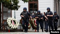 Police officers walk at the site of wreath laying ceremony after exchanges of gunfire in Vienna, Austria, Nov. 3, 2020. 