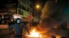 FILE - A rioter tries to throw bricks at police in the Mong Kok district of Hong Kong, Feb. 9, 2016.