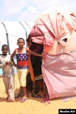 Two Yemeni boys posing next to their tent in the Yemeni Refugees Camp located in the outskirts of Somali capital Mogadishu. ( Courtesy of Muslim Aid)