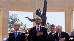 U.S. President Barack Obama and French President Francois Hollande stand with veterans during the playing of Taps, at Normandy American Cemetery at Omaha Beach in Colleville sur Mer, Normandy, France, June 6, 2014. 