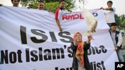 FILE - A woman releases a dove as a symbol of peace during a rally against the Islamic State group, in Jakarta, Indonesia. 