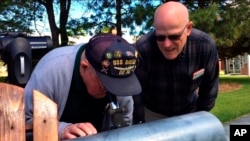 This frame grab from a video shows Gene Brick, 92, left, and his son, Bartt Brick, using a telescope in Madras, Oregon, June 12, 2017, that they made together in 1964. The two plan to watch the upcoming solar eclipse together, Aug. 21, 2017.