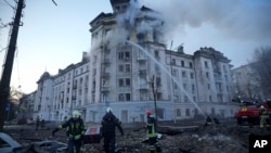 Petugas sedang berupaya memadamkan api di sebuah gedung setelah serangan Rusia di Kyiv, Ukraina, Kamis, 21 Maret 2024. (AP Photo/Vadim Ghirda)