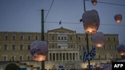 FILE: Protesters release hot air balloons in front of the Greek parliament as a tribute to the victims during a demonstration to protest against the EU and Greek government's policies following a deadly shipwreck which cost the lives of at least 78 migrants.