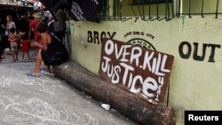 A sign reading "Overkill Justice for Eric" is displayed at the entrance of a street where Eric Quintinita Sison was killed in Pasay city, Metro Manila in the Philippines, Aug. 29, 2016. Family members of Sison said he was attempting to surrender when he was gunned down by police during a meth bust.