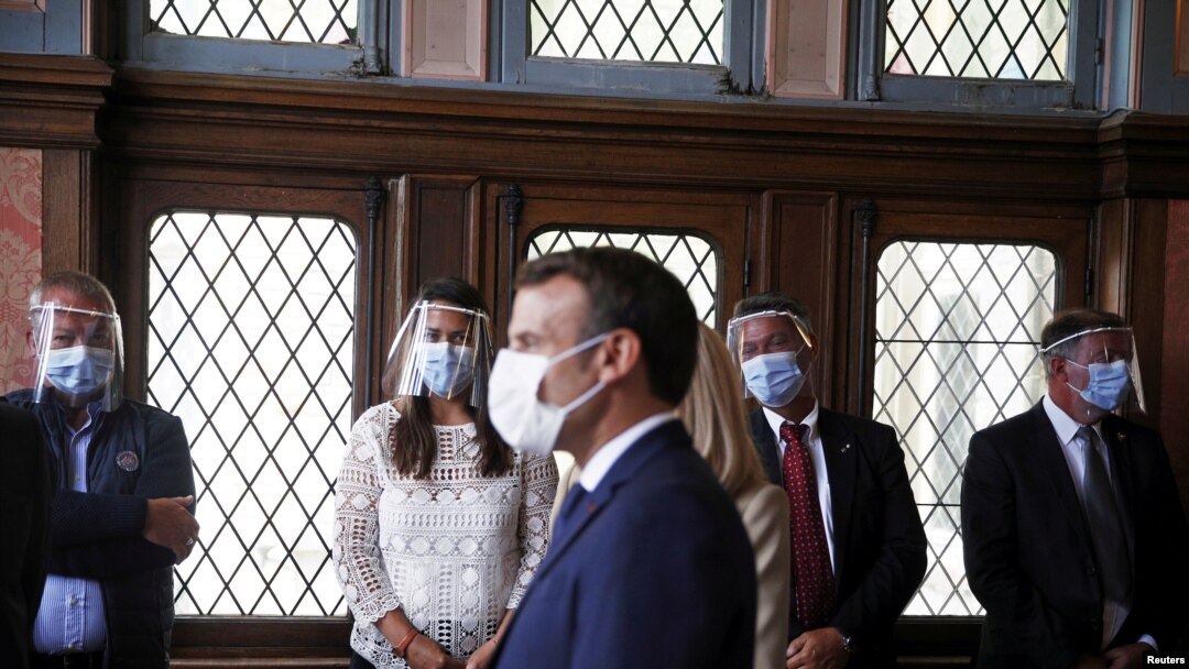 French President Emmanuel Macron speaks with officials at a polling station during the second round of French municipal elections, in Le Touquet-Paris-Plage, France, June 28, 2020.