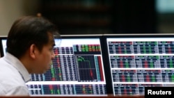 FILE - A stockbroker looks on his monitors inside the Philippine Stock Exchange (PSE) in Makati city, metro Manila, Feb. 29, 2016. 