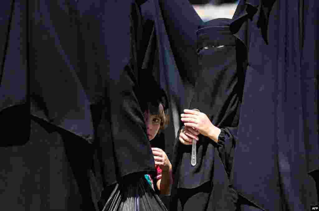 Syrian children wait with family members inside the Kurdish-run al-Hol camp, which holds relatives of suspected Islamic State fighters in the Hasakeh governorate, before being released from the camp to return home in the northern Raqqa region.