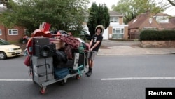 FILE - A squatter moves his belongings after being evicted from a housing estate in north London, Britain Sept. 24, 2015. The richest Britons are accumulating wealth three times as fast as the poorest, according to new official data.