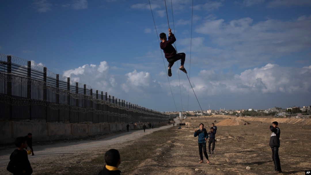 Palestinos desplazados por el bombardeo israelí del norte de la Franja de Gaza juegan cerca de la frontera con Egipto en Rafah, cerca del Corredor Philadelphi, sur de la Franja de Gaza el 14 de enero del 2024.