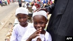 Des frères jumeaux, Salim et Mahamadou Cisse, près de leur mère alors qu’ils mendient sur un marché à Abobo, dans la banlieue d’Abidjan, le 6 septembre 2018.