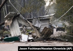 Debris block a portion of Porter Lane after strong thunderstorms pass through the Greater Houston region in Texas, Dec. 28, 2024. (Jason Fochtman/Houston Chronicle via AP)