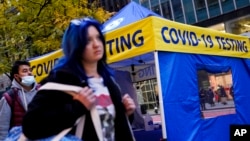 Pedestrians pass a COVID-19 testing tent on 42nd Street, Dec. 2, 2021, in the Manhattan borough of New York. 