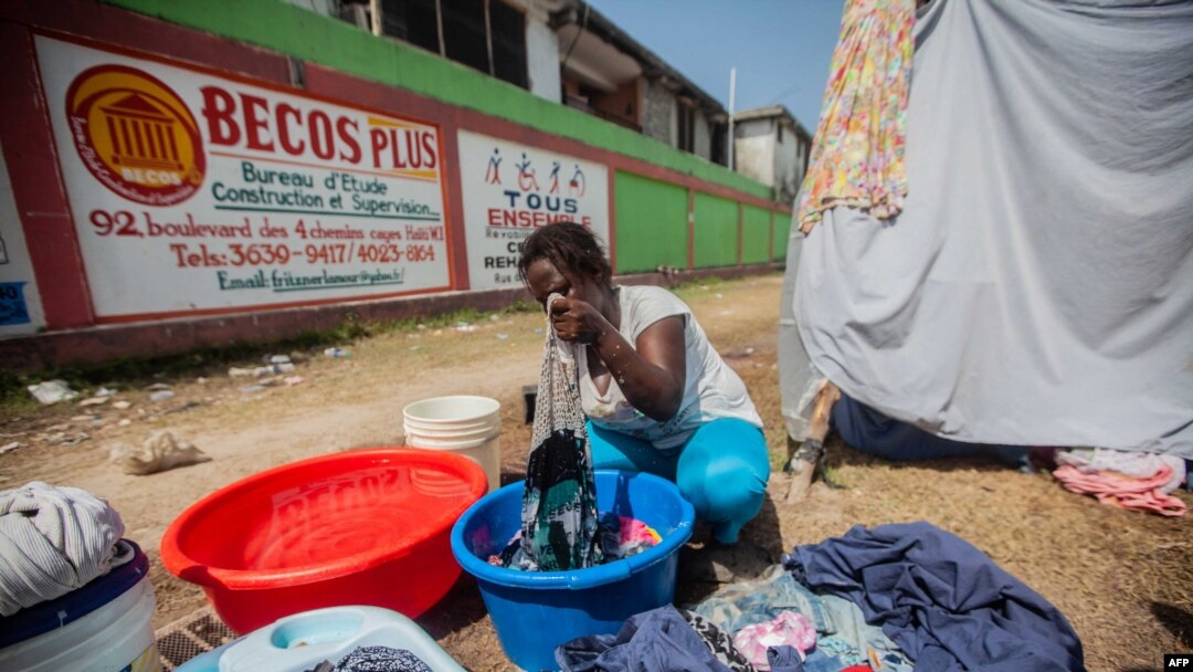 A woman washes clothes at a camp for people who lost their homes during the Aug. 14 earthquake, in Les Cayes, Haiti, Aug. 23, 2021.
