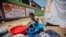 A woman washes clothes at a camp for people who lost their homes during the Aug. 14 earthquake, in Les Cayes, Haiti, Aug. 23, 2021.