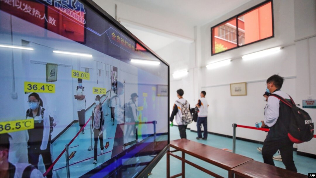 Siswa SMA di Wuhan, China, berjalan melewati pemindai suhu badan di Wuhan, provinsi Hubei, 6 Mei 2020. (Foto: dok).