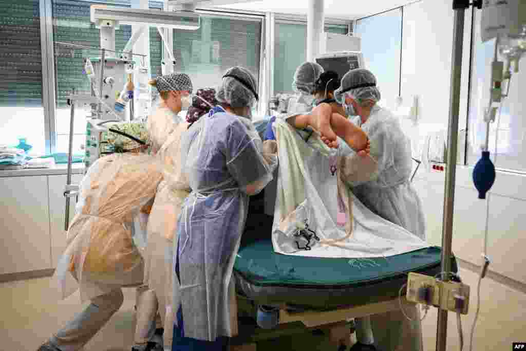 Members of the medical staff hold a patient infected with COVID-19 at the intensive care unit of the Andre-Gregoire Intercommunal Hospital, in Montreuil, Seine-Saint-Denis, on the outskirts of Paris, France.